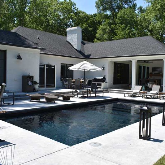 Fiberglass swimming pool and patio with lounge chairs