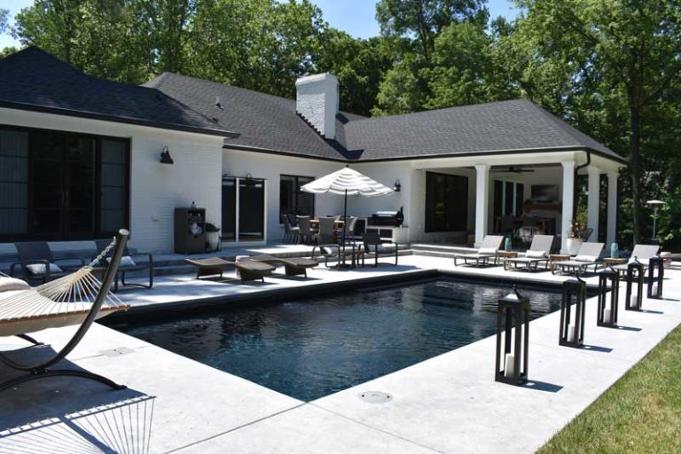 Backyard Paradise Fiberglass swimming pool and patio with lounge chairs