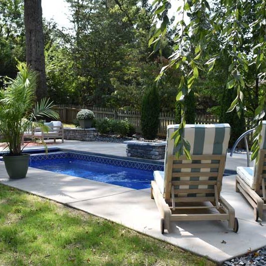 Seating and landscape around fiberglass pool