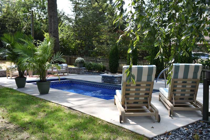 Seating and landscape around fiberglass pool