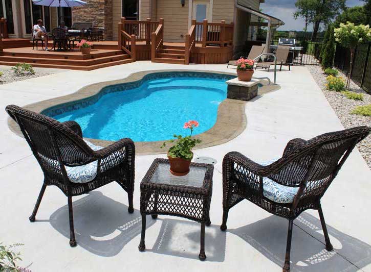 Fantasy Patio and swimming pool with couple sitting on deck in the background