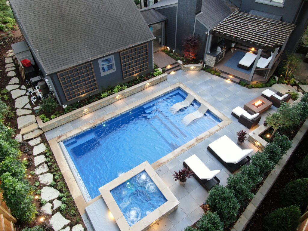 Aerial view of The illusion swimming pool with pool house and beautiful landscape in the backyard