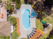 Complete pool project with River Pools C40 with spillway in Caribbean Sparkle with concrete paver patio and natural stone coping